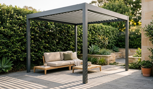 F150 Vega aluminium louvered pergola with a sofa on a patio area surrounded by greenery